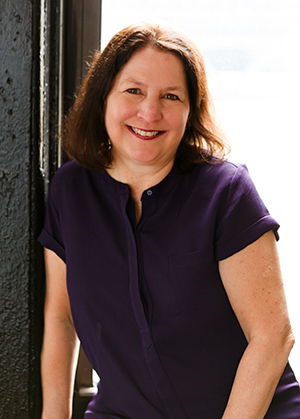 Headshot of Kim Shivler sitting on windowsill.